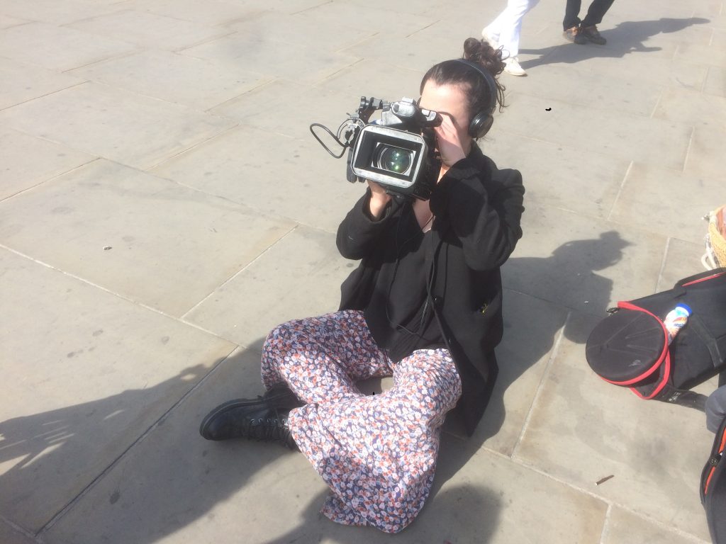 Francesca Nicholls, a young Journalist, holding a camera