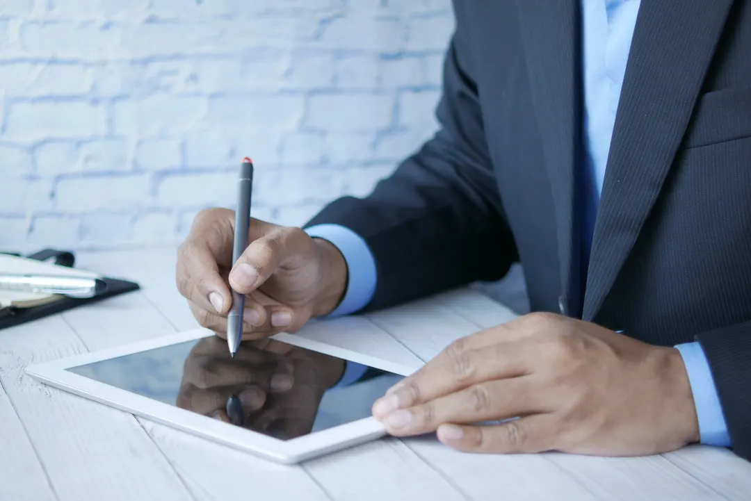 Close up of man in suit, using a tablet