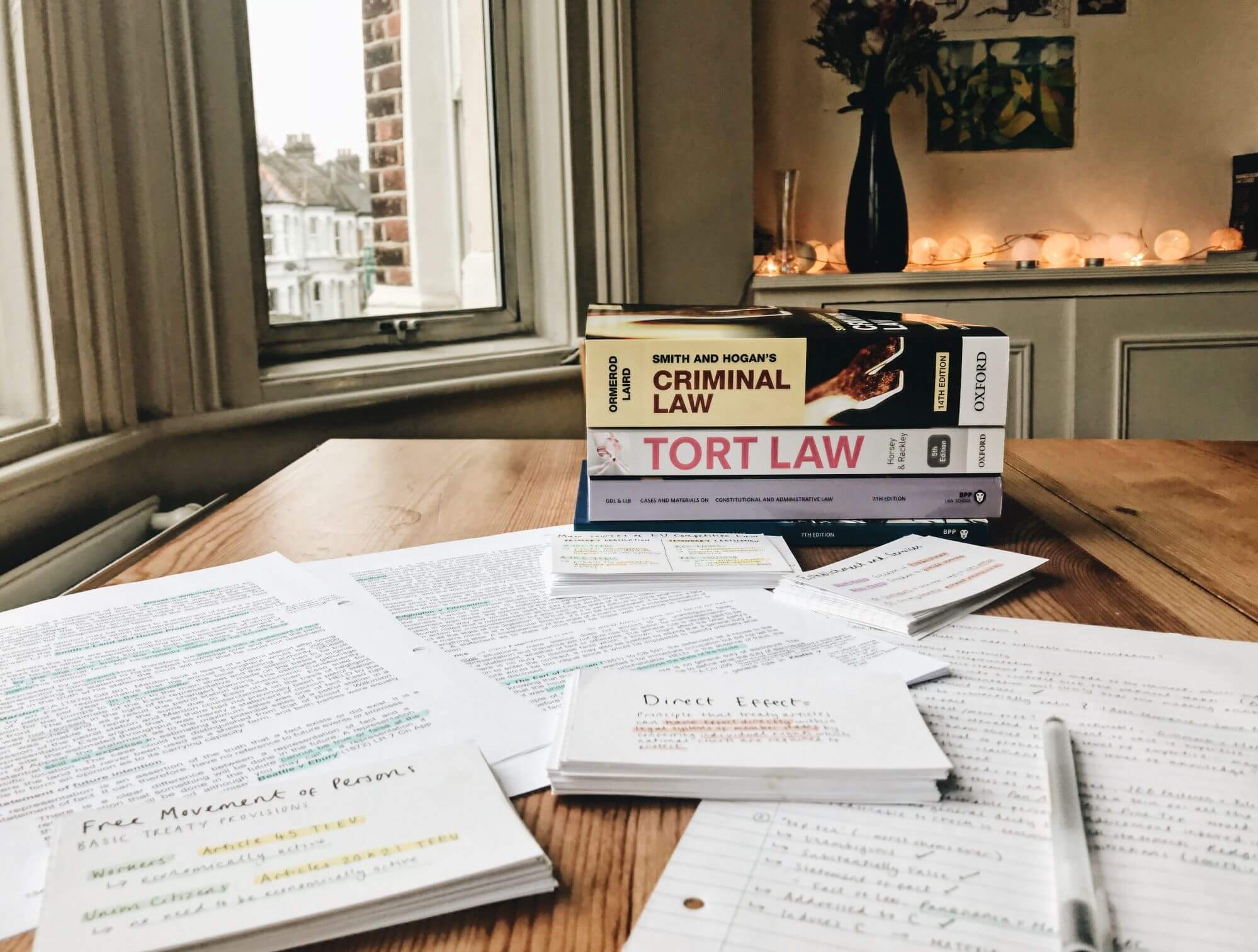 Law student's textbooks for tort law and criminal law on a table.