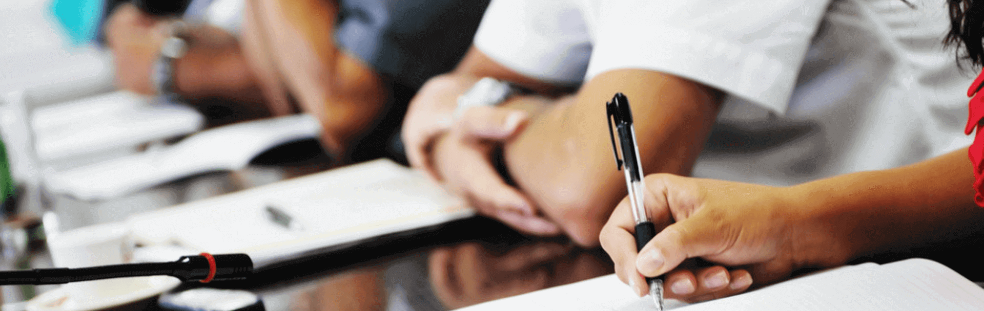 A student writing medical notes during a lecture