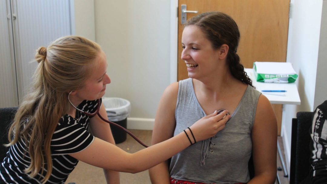 A medical student checking a girls heart rate for a medical lab