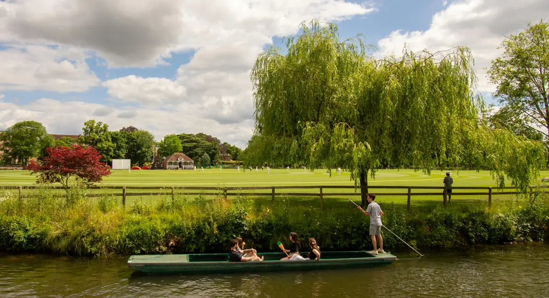 Wide shot of people punting along the river in Oxford