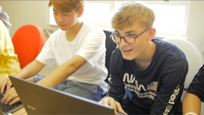 Teenagers learning computer skills at summer school