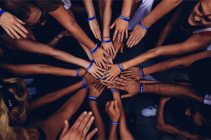 Students volunteering and putting their hands together for a third-sector organisation