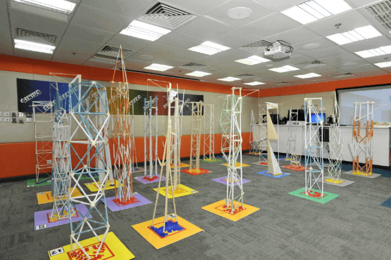 Several paper tower projects being displayed at an engineering summer camp