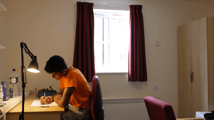 A student studying in his dorm at summer school A student studying in his dorm at summer school
