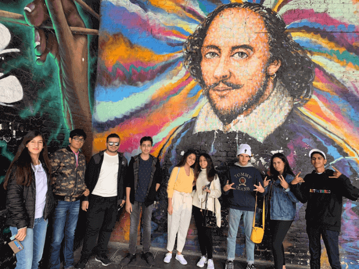 Students in front of a mural of Shakespeare in London, England