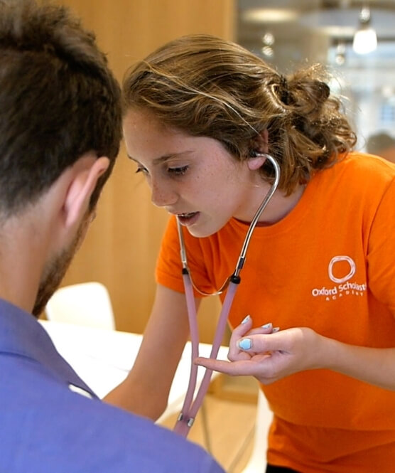 A high school medical student learning to use a stethoscope
