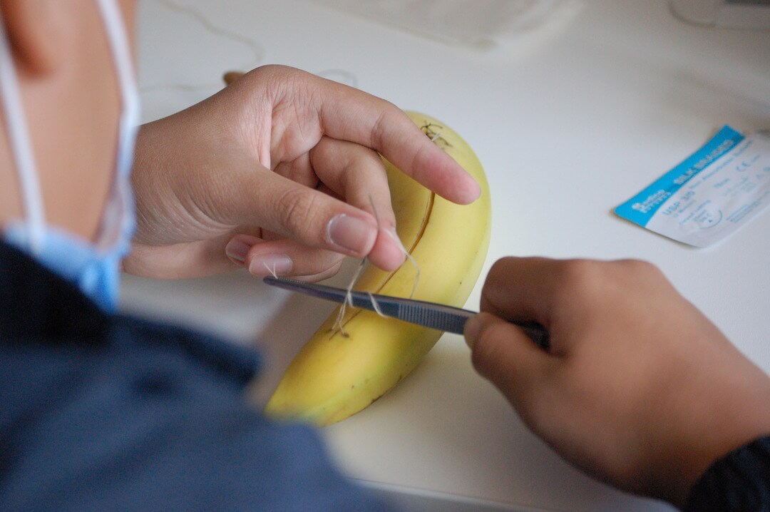 An Oxford Scholastica Student practicing suturing during a summer Medicine course.