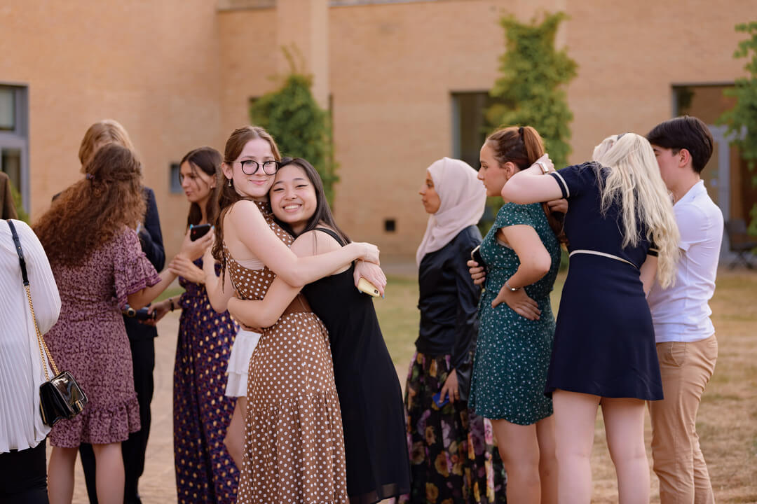 Two Oxford Scholastica Academy summer school students hugging.
