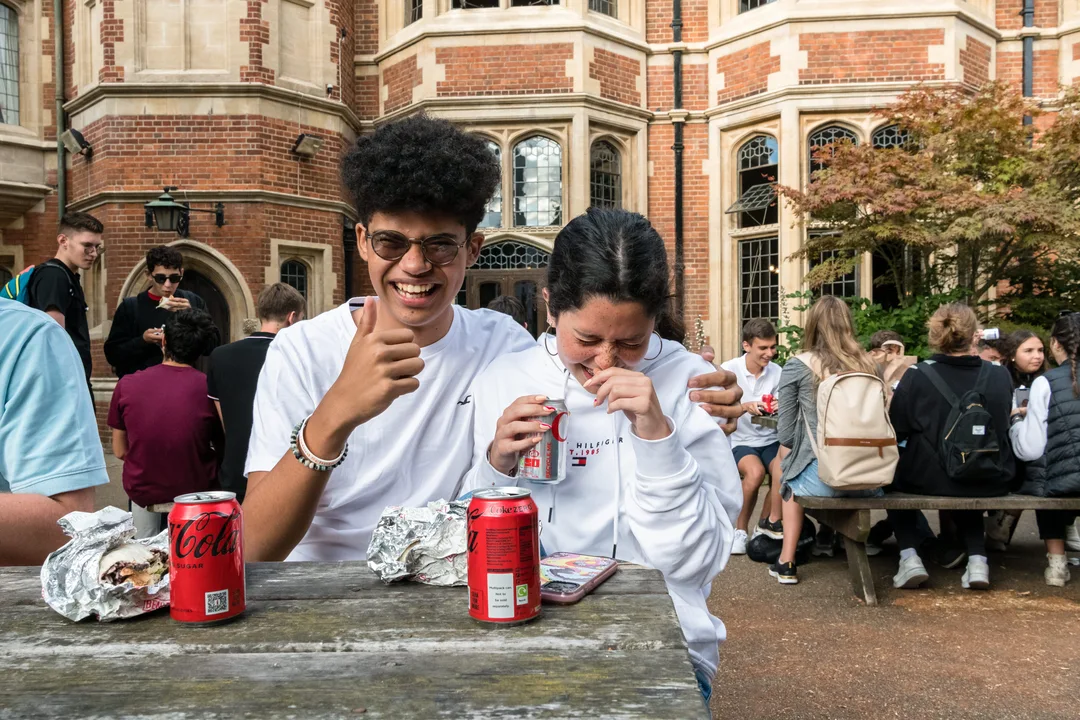 Two Oxford Scholastica students laughing at a table