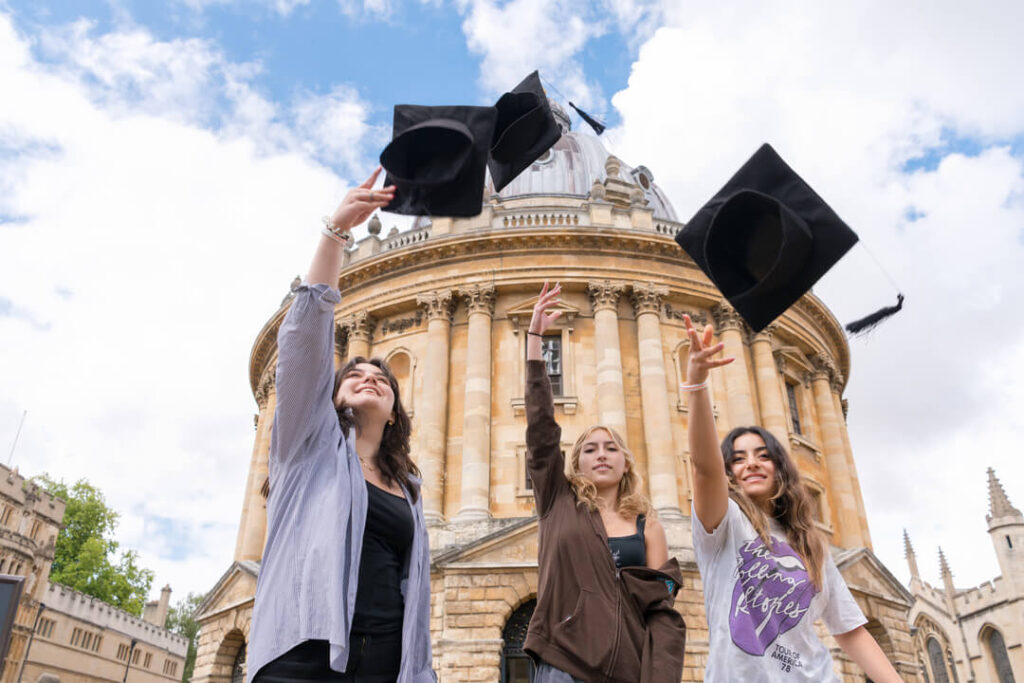 Oxford Scholastica summer school students, throwing graduation caps in the air in Oxford.