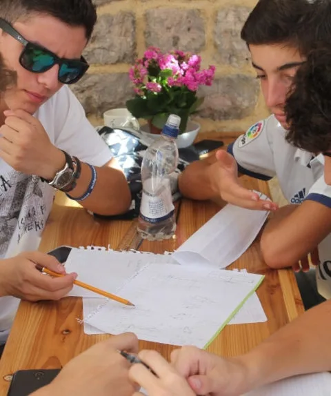 Engineering students working in a group around a table at an Oxford Scholastica summer school. 