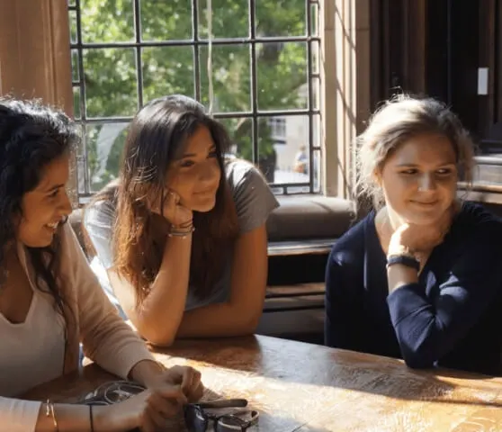 three Oxford Scholastica students sat around a table at the Oxford Union