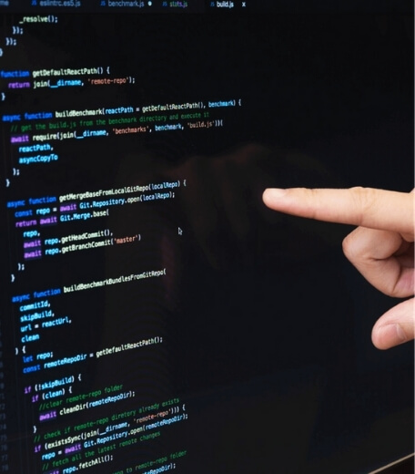 A person's finger pointing at a code on a screen.