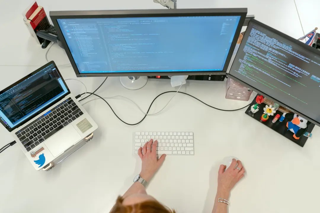 Computer Science student using a MacBook Pro on a white table