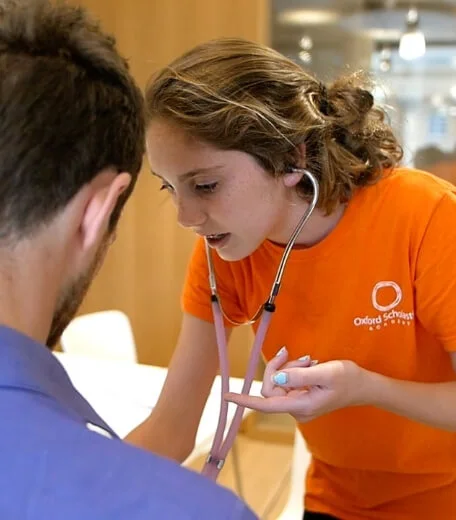 A student listening to a patient's heartbeat during a summer school.