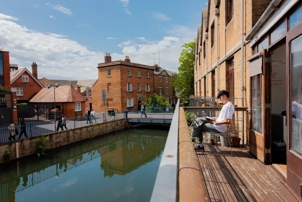 Oxford Scholastica Academy student reading outside their accommodation by the canal