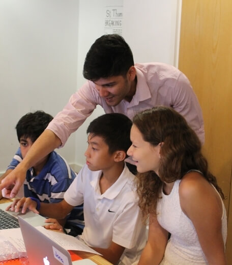 A tutor explaining the objective to students at an Oxford Scholastica summer school.