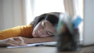 Woman who has fallen asleep at her desk whilst studying
