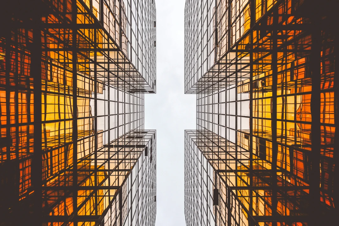 Worm's eye view of two orange reflective buildings