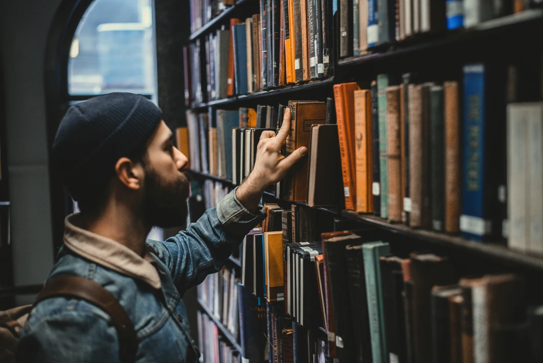 Person removing a book from a library shelf