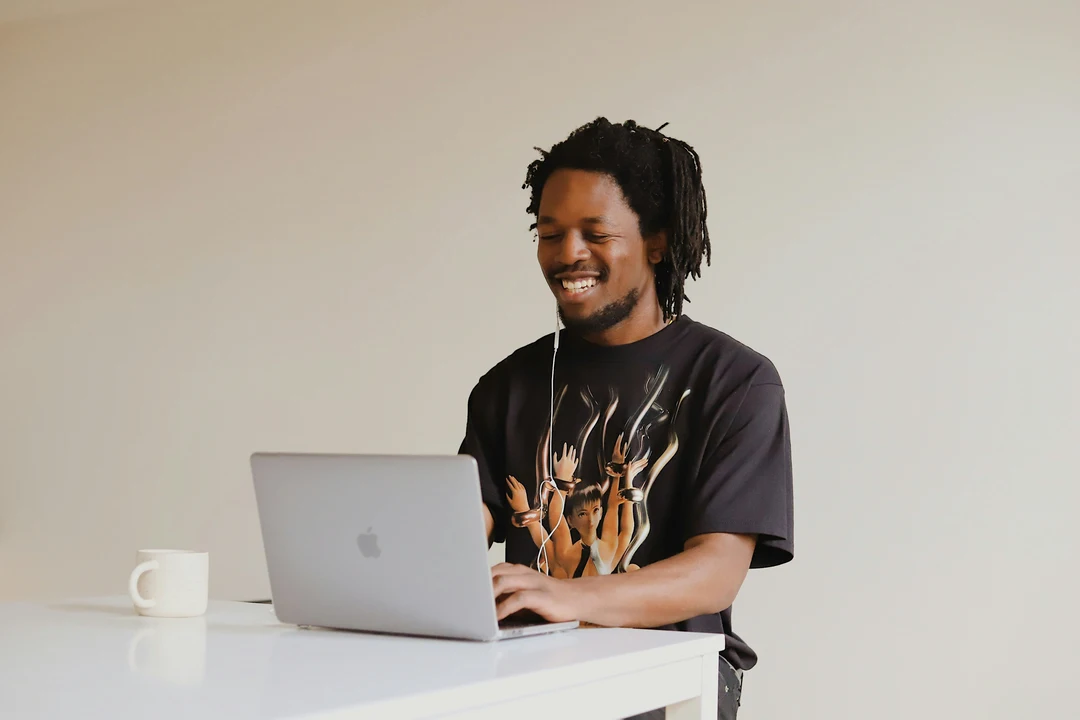 Smiling student typing on laptop