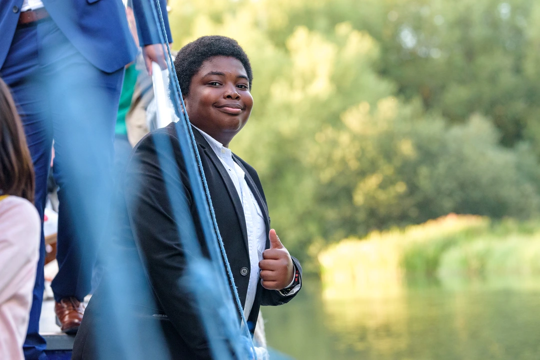 Oxford Scholastica student on a river boat, giving a thumbs up to the camera