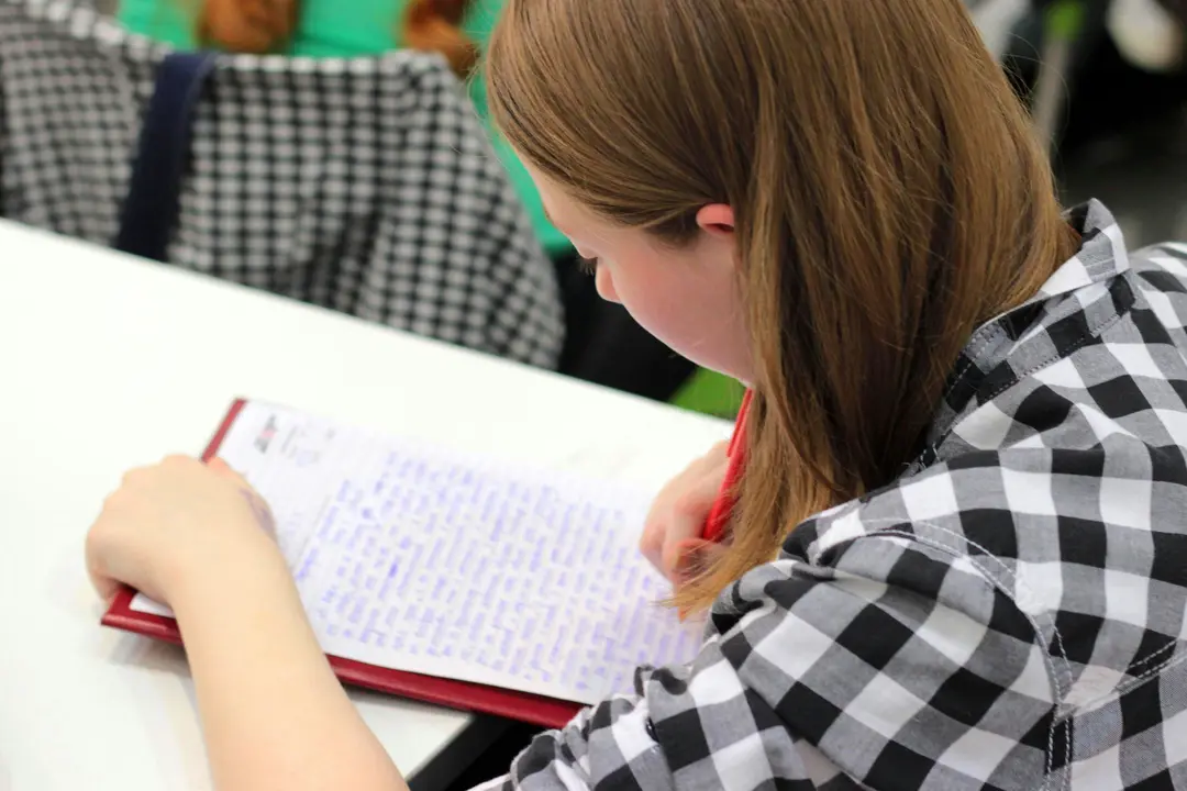 Student writing prose in a workbook