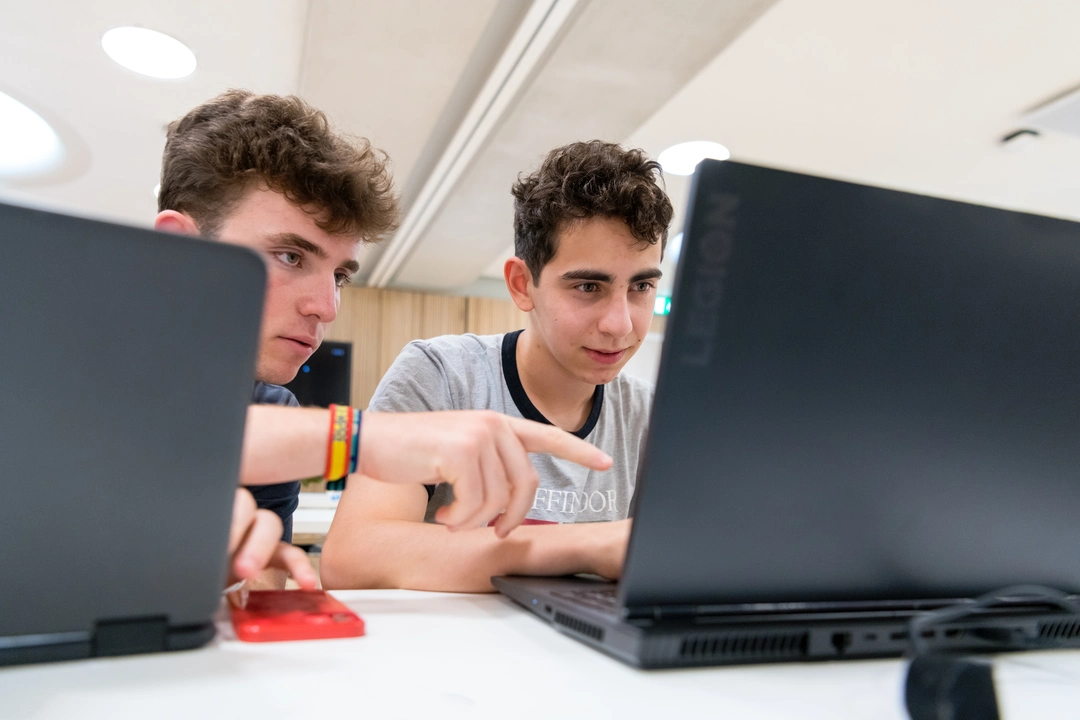 Two students working together on a laptop