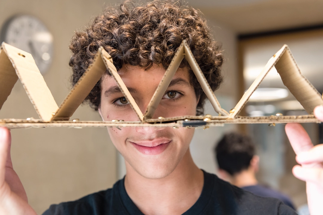 Student holding up a cardboard model to the camera