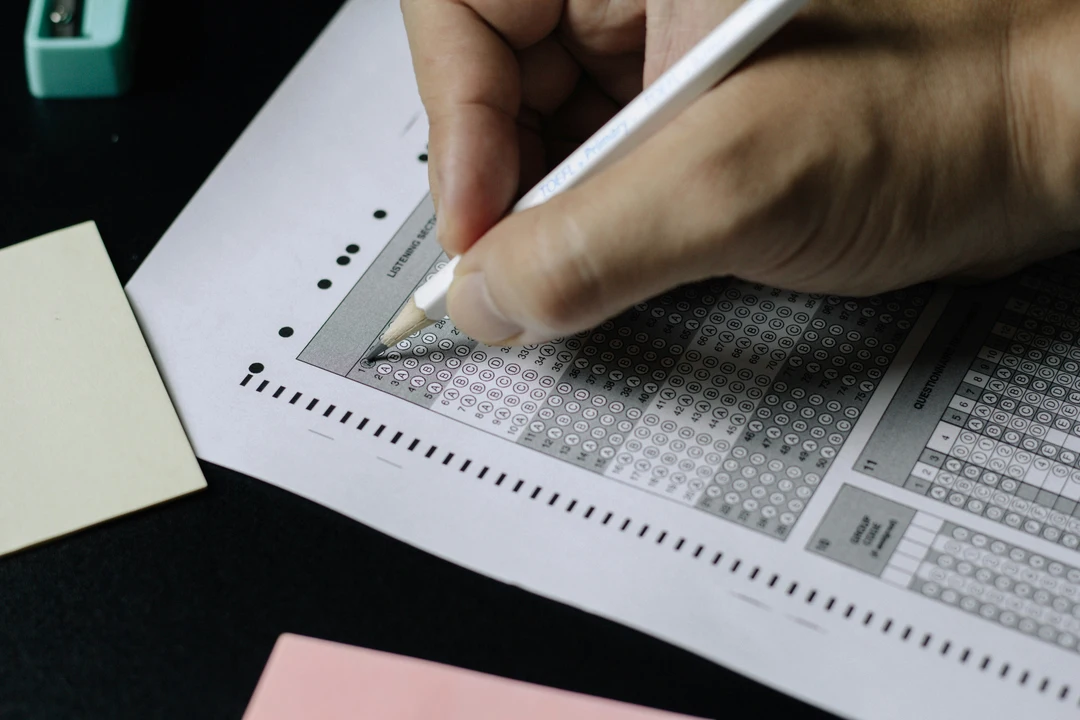 Close up of hand filling out exam answer paper