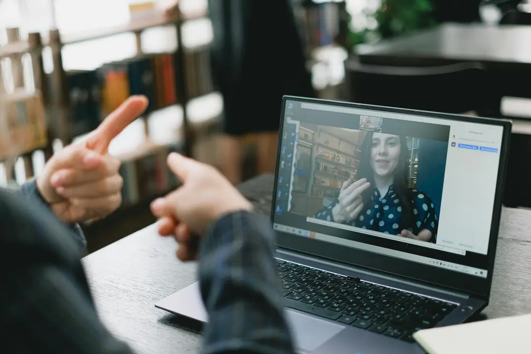 Two people communicating over a video call using sign language