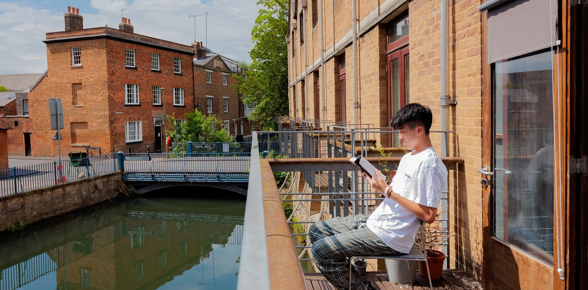 OSA student reading a book by a canal